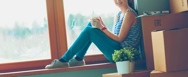 Ablakpárkányon csésze új otthon ülő lány — Stock Fotó