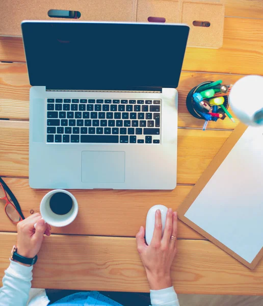 Jeune femme travaillant assise à un bureau — Photo