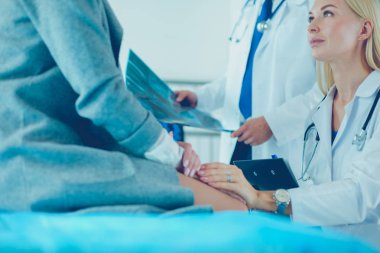 Doktor ve hasta tarama sonuçlarını tarama merkezinde tartışıyor