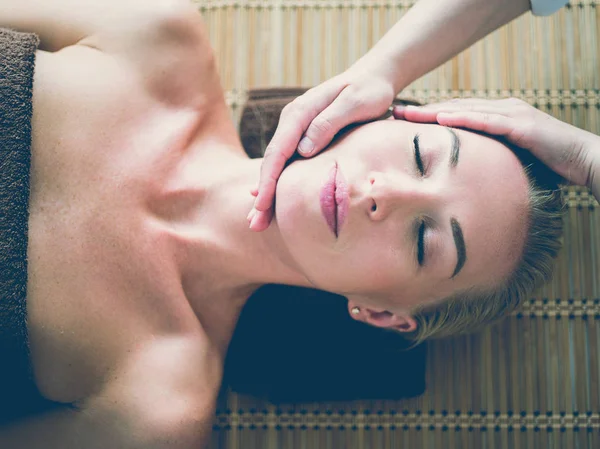Молода жінка насолоджується масажем у спа-салоні — стокове фото