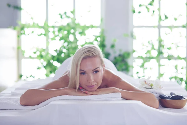 Mujer joven disfrutando de masajes en el salón de spa. —  Fotos de Stock