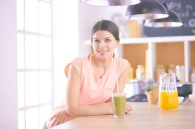 Mutfakta masada oturan genç bir kadın.