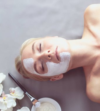 Yüz maskesi. Güzel genç kız Spa, makyajcısı kadın yüz maskesi uygulama.