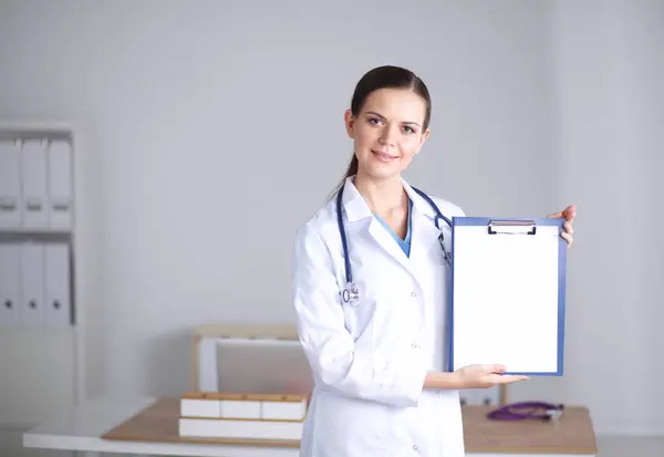 微笑的女医生，穿着制服站着的文件夹微笑的女医生 — 图库照片