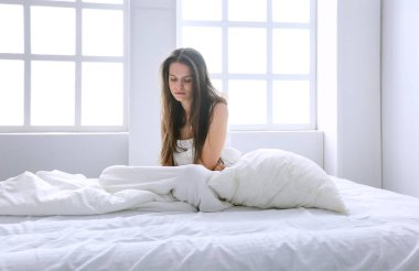 Genç kadın duygu ağrı yatakta.