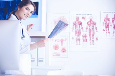 Genç, profesyonel kadın doktor hastaların röntgenlerini çekiyor.