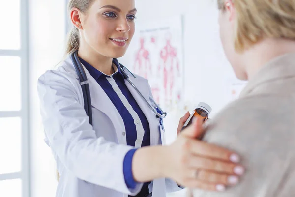 Dokter en patiënt bespreken iets terwijl ze aan tafel zitten. Begrip "geneeskunde en gezondheidszorg" — Stockfoto