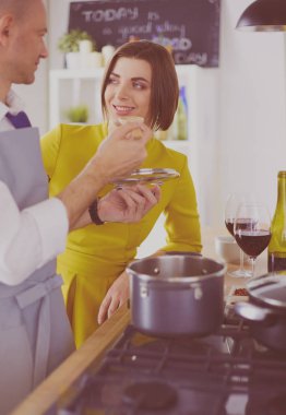 Evdeki mutfakta birlikte yemek pişiren çift.