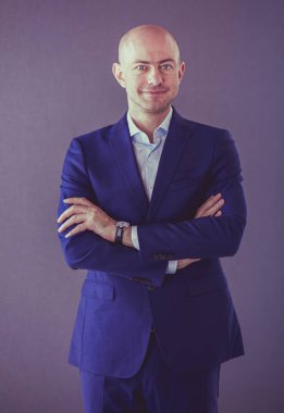 Gri bir arka plan üzerinde mavi elbiseli Genç çekici adam. İzole