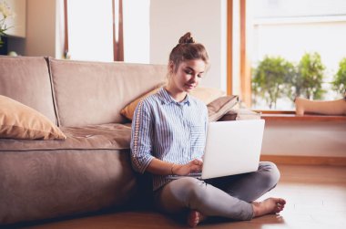 oturma odasında yere üstünde laptop ile mutlu bir kadın