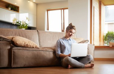 oturma odasında yere üstünde laptop ile mutlu bir kadın