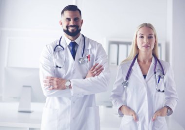 Bir doktor ekibi, kadın ve erkek, danışma odasında.