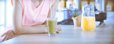 Mutfakta masada oturan genç bir kadın.