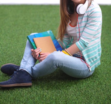 Yeşil çimlerde oturan genç bir kadın. Portreit genç bayan