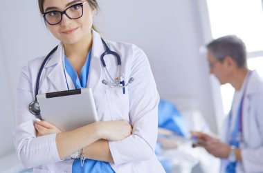 Hastane lobisinde tablet bilgisayar kullanan kadın doktor.