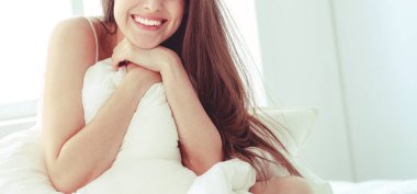 Güzel bir kadın yatağında uzanıyor..