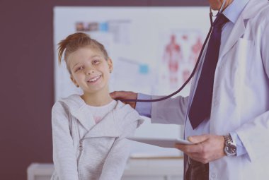Steteskoplu kız ve doktor kalp atışlarını dinliyor.