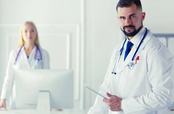 Щаслива медична команда лікарів, чоловік і жінка, ізольовані на білому тлі в лікарняній кімнаті — стокове фото