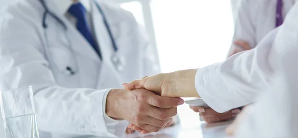 Доктор пожимает руку пациенту в офисе — стоковое фото