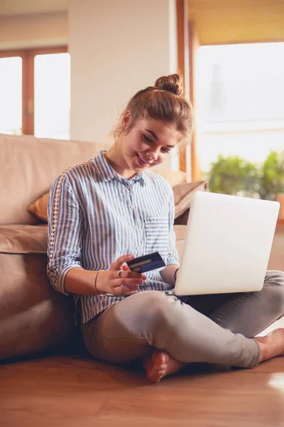 Hermosa mujer joven usando tarjeta de crédito y portátil para compras en línea — Foto de Stock