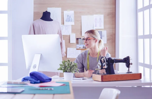 Mooi jong meisje in een fabriek met een naaimachine aan de tafel — Stockfoto