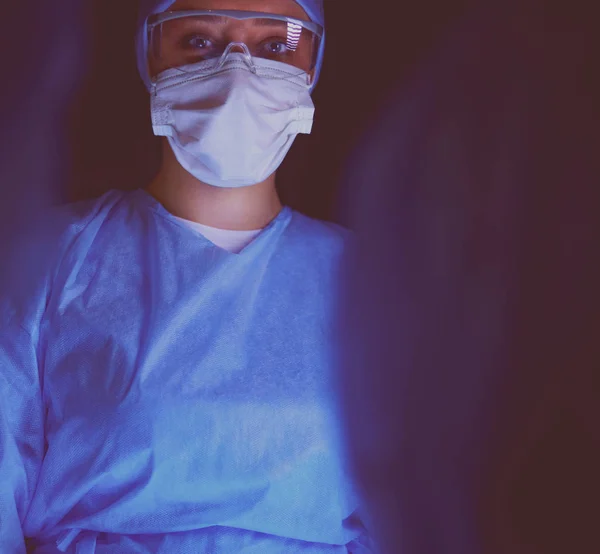 Team di medici in chirurgia su sfondo scuro. — Foto Stock