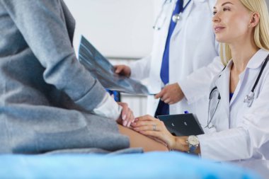 Doktor ve hasta tarama sonuçlarını tarama merkezinde tartışıyor