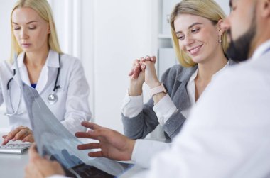 Doktor kadın hastanın göğüs röntgenini gösteriyor.