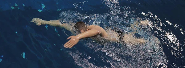 Joven nadando por delante gatear en una piscina — Foto de Stock