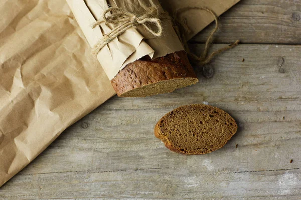 Pane affettato confezionato in carta su tavolo di legno — Foto Stock