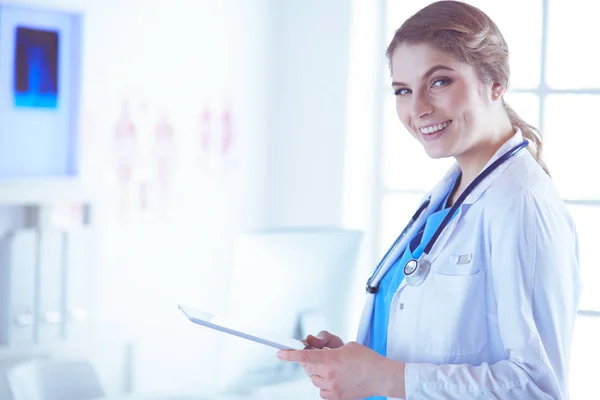 Female doctor using tablet computer in hospital lobby — Stock Photo, Image