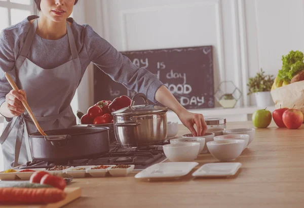 Koken vrouw in keuken met houten lepel — Stockfoto