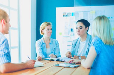 Masada kitaplarla çalışan gençler. Güzel kadınlar ve erkekler birlikte çalışıyor..