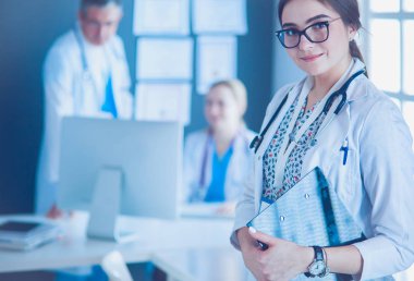 Kadın doktor hastanede steteskopla dikiliyor.