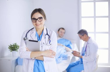 Hastane lobisinde tablet bilgisayar kullanan kadın doktor.