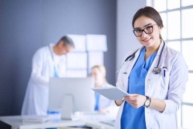 Hastane lobisinde tablet bilgisayar kullanan kadın doktor.