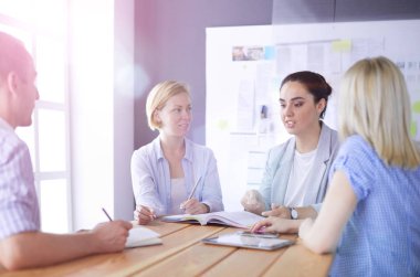 Masada kitaplarla çalışan gençler. Güzel kadınlar ve erkekler birlikte çalışıyor..