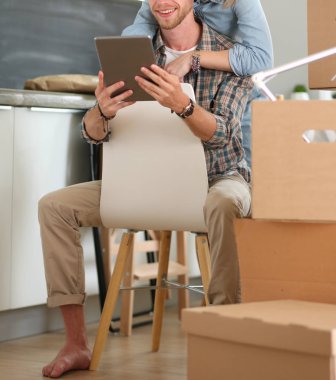 Genç bir çift yeni ev içinde hareket. Oturma ve açma sonra rahatlatıcı. Bir şey üstünde laptop arıyorum. Genç Çift