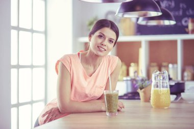 Mutfakta masada oturan genç bir kadın.