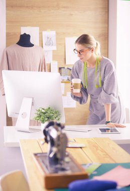 Moda tasarımcısı kadın dikiş makinesiyle dikiş dikiyor