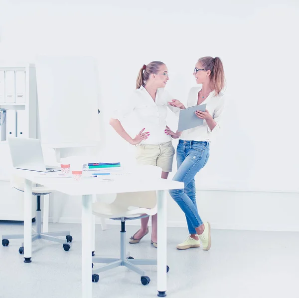 Deux femmes travaillant ensemble au bureau, assises sur le bureau — Photo