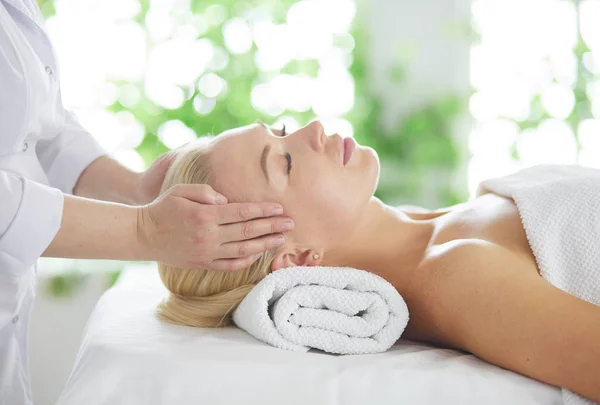 Mulher bonita fazendo massagem facial em um salão de spa. — Fotografia de Stock