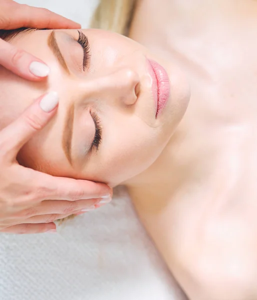 Jeune femme allongée sur une table de massage, relaxante les yeux fermés. Femme. Salon de spa — Photo