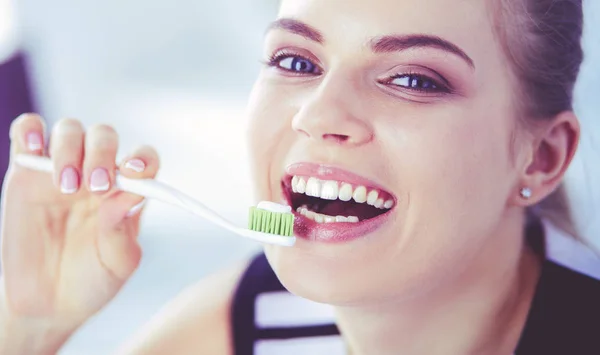 Joven chica bonita manteniendo la higiene bucal con cepillo de dientes . —  Fotos de Stock