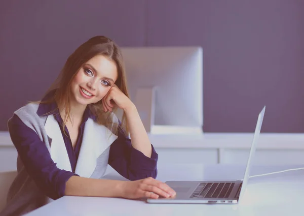 Joven empresaria confiada trabajando en el escritorio de la oficina y escribiendo con una computadora portátil — Foto de Stock