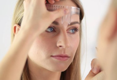 Kaşlar için kalıcı makyaj. Güzellik salonunda kalın kaşlı güzel bir kadın..