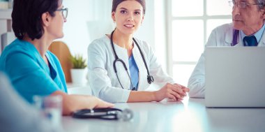 Doktorlar hastane konferans odasında birbirlerine danışıyorlar.