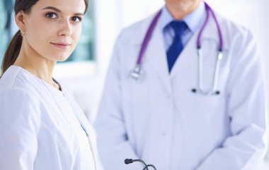 İki doktor hastanedeki konferans odasında, biri kameraya bakıyor.