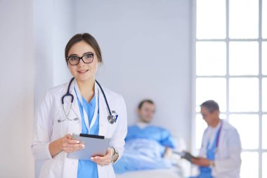 Hastane lobisinde tablet bilgisayar kullanan kadın doktor.