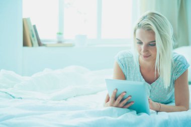 Güzel bir kadın yatağında uzanıyor.